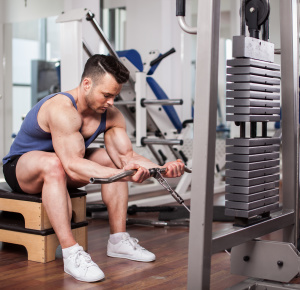 Athletic man pulling up heavy weights at the gym